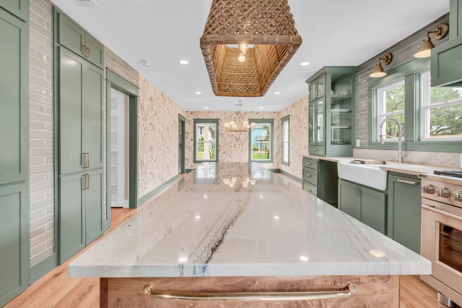 Sage green shaker kitchen with marble island and brass hardware, whole-home renovation by Vertical Ventures Inc in Corpus Christi